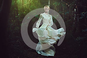 Elfin woman dancing in fairy forest photo