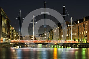 Eliasson Cirkelbroen Five Circles Pedestrian Bridge across a canal illuminated at night in a modern residential area. Copenhagen