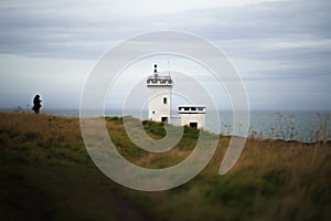 Elie Ness Lighthouse in the green field at the shore