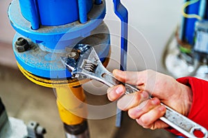 Elimination of a problem in the boiler room of an apartment building. The process of connecting pipes and tightening nuts with an