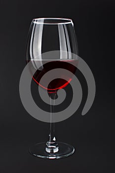 Elite red wine in glass on black background.