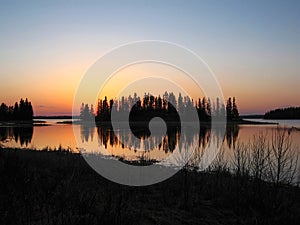 Elk Island National Park Sunset behind Wooded Island in Astotin Lake, Alberta, Canada