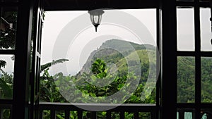 Ella Rock view from open terrace with plants. Scenic landscape from hill country villa. Panoramic mountain panorama in