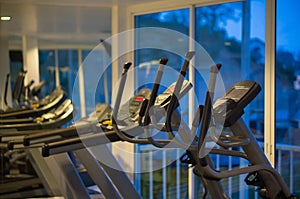 Elliptical cross trainers in a fitness gym at evening