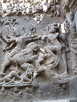 Stone carving of Durga, principal aspect of mother goddess Devi, on a lion, attacking a horned demon, Kailasa Temple, Ellora photo