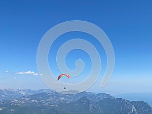 Ellow Paraglider tandem instructor with a tourist flying into the sky with clouds on a sunny day