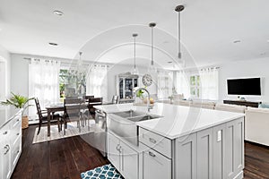A white kitchen looking towards a dining and living room.