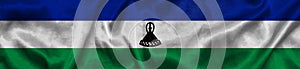Elongated national flag of Lesotho with a fabric texture fluttering in the wind. Lesotho flag for website design. 3d photo