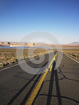Elongated Shadows of Two People on Road
