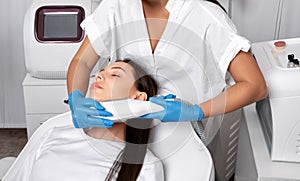 Elos epilation hair removal procedure on the face of a woman. Beautician doing laser rejuvenation on the chin in a beauty salon. photo