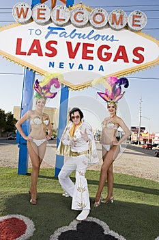 Elvis Presley Impersonator Standing With Casino Dancers