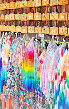 Ema prayer tablets and strings of paper origami cranes. Wishes written in Japanese on the plaques.