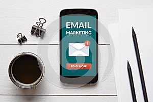 Email marketing concept on smart phone screen with office object