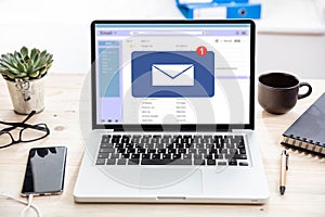 Email message inbox notification on laptop screen, business background