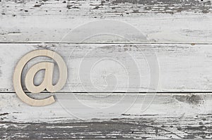 Email sign on a old white wood lies on a vintage wooden table. Concept e-mail message letter. Top view with copy space