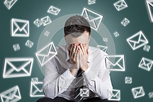 Email symbols swirling around an overstrained man