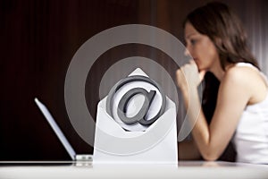 Emailing concept: At letter with woman and laptop.