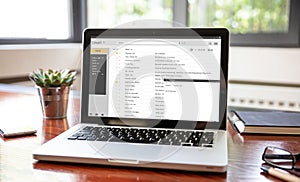 Emails list on a laptop screen, office workspace