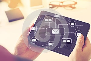 Emails with person holding tablet computer