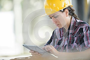 emale construction worker reading something on tablet computer