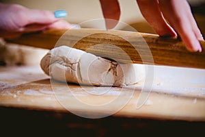 Emale hand rolled dough on a pizza