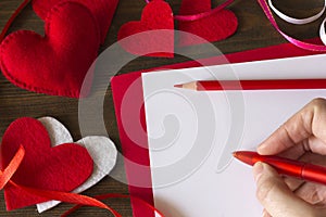 Emale hand writes a note on Valentine`s Day