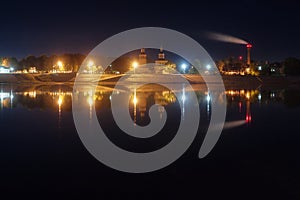 Embankment of an ancient city reflected in the river at night