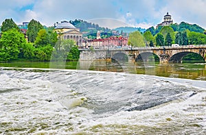 The rapid on Po River with Vittorio Emanuele I Bridge and Santa Maria al Monte dei Cappuccini Church, Turin, Italy