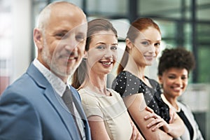 Embarking on success together. Portrait of a group of businesspeople standing together in a modern office.