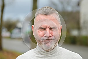 Embarrassed or anguished man screwing up his face photo