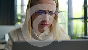 Embarrassed Caucasian woman businesswoman girl in eyeglasses looking at laptop computer overwork female office worker