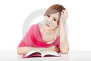 Embarrassed girl studying with book photo