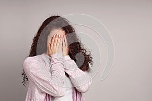 Embarrassed young woman hiding her face