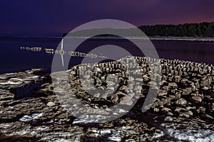 Embedded stones and harbor ruins in Narva-JÃµesuu. Rocky beach, peaceful sea and port.