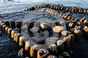 Embedded stones and harbor ruins in Narva-JÃµesuu. Rocky beach, peaceful sea and port.