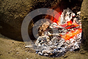 Embers of a dying fire in a wood fired stove made out of mud and