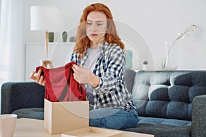 Embittered woman opening just delivered item after home shopping