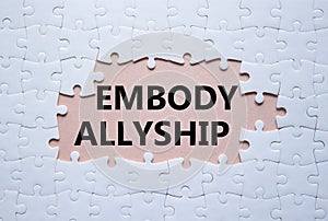 Embody Allyship symbol. Concept word Embody Allyship on white puzzle. Beautiful pink background. Business and Embody Allyship photo