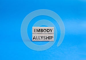 Embody Allyship symbol. Concept word Embody Allyship on wooden blocks. Beautiful blue background. Business and Embody Allyship photo