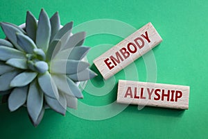 Embody Allyship symbol. Concept word Embody Allyship on wooden blocks. Beautiful green background with succulent plant. Business photo