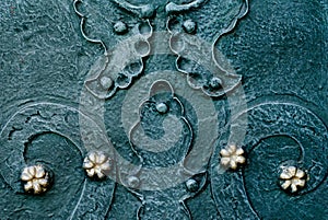 Embossed metallic green-blue background with baroque details and with buttons metal gold flowers