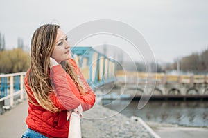 Embrace being single, Art of Being Happily Single. Woman in red jacket walks by the river alone. calm scene