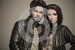 Embraced modern couple in leather jackets smiling photo