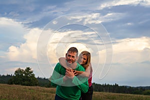 Embracing couple, man and woman in meadow at sunset cloud sky. Relationship, married, love concept