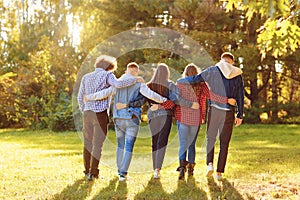 Embracing friends walking together in park photo