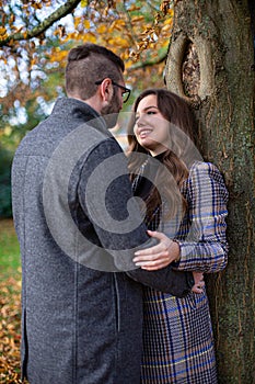 Embracing young man and woman near the tree