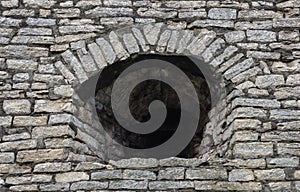 Embrasure in old gray stone wall photo