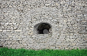Embrasure in old white stone wall photo