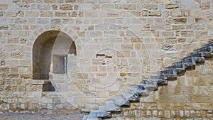 An embrasure and a staircase on the stone wall of an ancient for