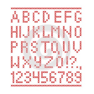 Embroided by cross stitch english alphabet with numbers and symbols on white background.